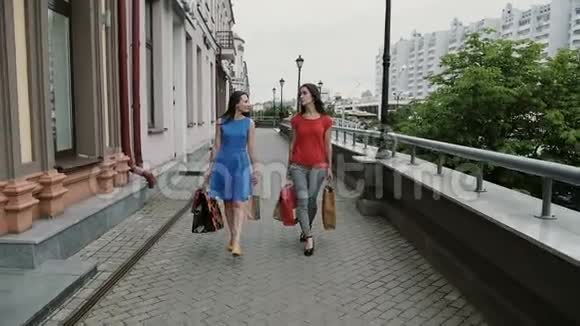 快乐的年轻女性朋友带着购物袋走路聊天讨论玩得开心缓慢的莫史泰康射击视频的预览图
