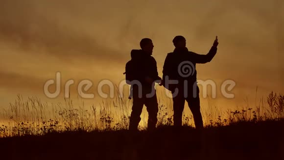 两名游客在夕阳的阳光下自拍旅行两个人穿夹克做自拍生活方式秋天视频的预览图