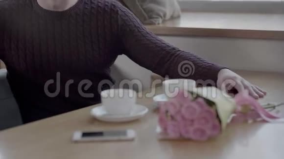 男人在咖啡厅给年轻女人送花日期恋爱中的情侣视频的预览图