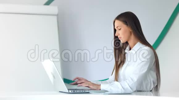 漂亮的女商人在白色办公室工作手提电脑视频的预览图
