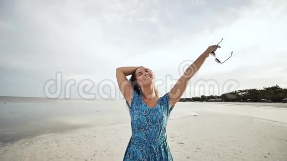 一个年轻的俄罗斯女孩带着快乐的情绪走在海滩上在镜头前摆姿势女孩是视频的预览图