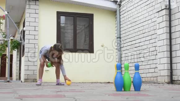 五岁的女孩在院子里玩儿童保龄球视频的预览图
