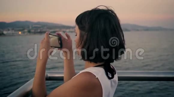 黑发女人拍日落的照片视频的预览图