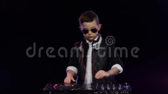 时尚男孩DJ与眼镜玩乙烯基黑色背景视频的预览图
