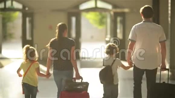 母亲父亲太阳和女儿带着书包和手提箱离开火车站视频的预览图