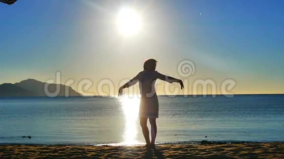 海洋日出海滩上一个年轻女孩的剪影视频的预览图