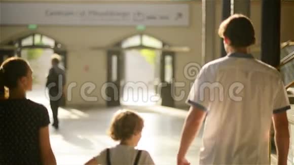 母亲父亲太阳和女儿带着书包和手提箱离开火车站视频的预览图