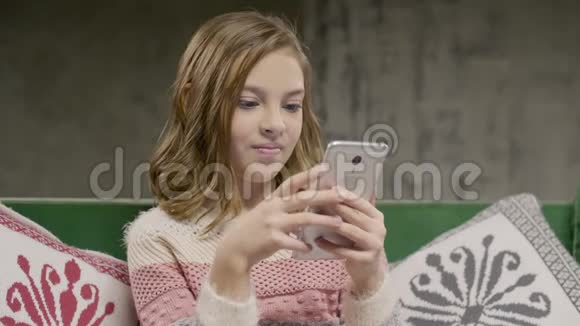 少女在家里用智能手机和朋友聊天视频的预览图
