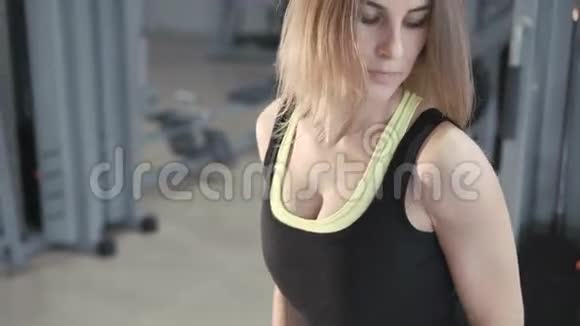 4K的漂亮女孩在健身房里用哑铃锻炼视频的预览图
