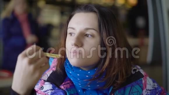 女孩从街上跑进咖啡馆很快就会吃东西黑发女人穿着运动夹克吃法语视频的预览图