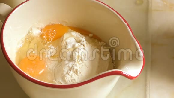 在鸡蛋和面粉中加入牛奶使面糊混合在罐子里视频的预览图
