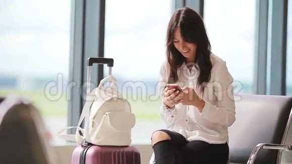 航空公司乘客在机场休息室等待航班飞机白种人女人在候诊室用手机说话视频的预览图