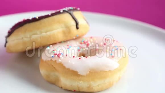 在粉红色背景上有两个甜甜圈的旋转板视频的预览图