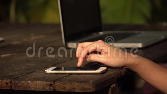 使用带有木制桌子的智能手机触摸屏的女性视频的预览图