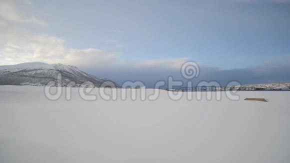 在特罗姆塞德伦和特罗姆塞城的岛屿上长而白色的雪域有着强大的山峰和日出的太阳视频的预览图