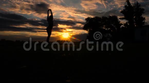日落时分女人在沙滩上举起手臂慢动作视频的预览图