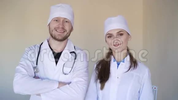 年轻的女医生和一位男医生看着相机微笑4K视频的预览图