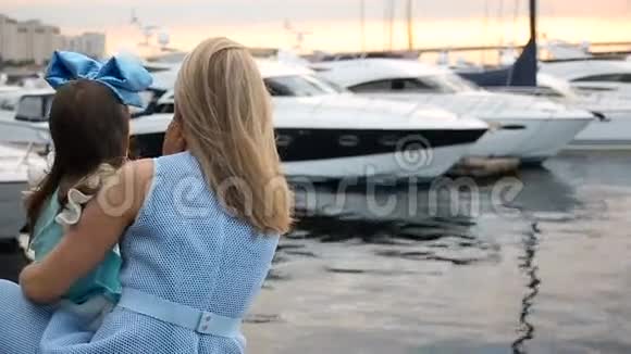 母亲和女儿穿着蓝色的裙子站在码头上的蓝色大弓视频的预览图