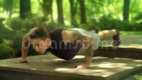 在公园里做俯卧撑运动的人户外俯卧撑的健身男子视频的预览图