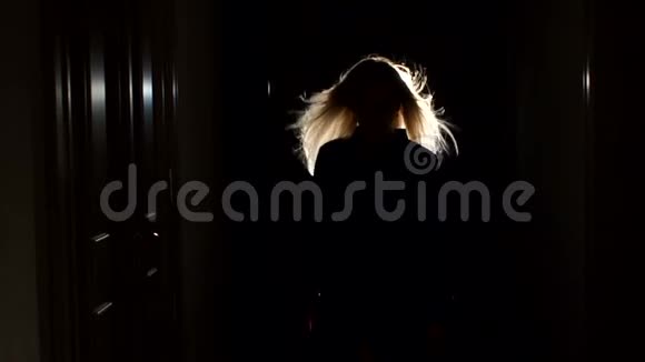 黑暗中长廊里金发飘飘的女孩剪影视频的预览图
