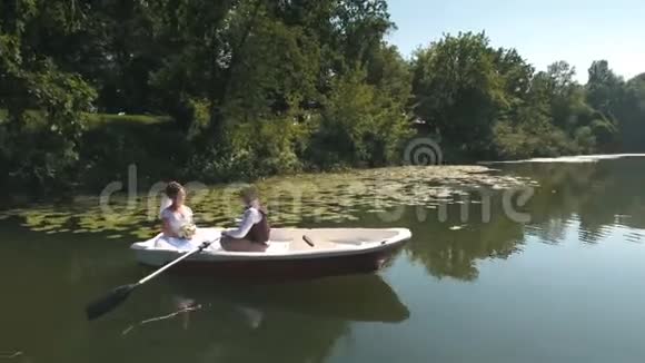 情侣的鸟瞰图漂浮在木湖上的小船上视频的预览图