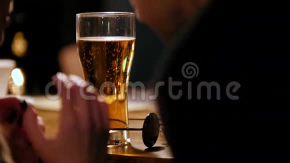 酒吧里的故事女人喝啤酒和朋友聊天在酒吧柜台上戴黑眼镜视频的预览图