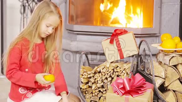 快乐的好女孩在壁炉旁打开圣诞礼物视频的预览图
