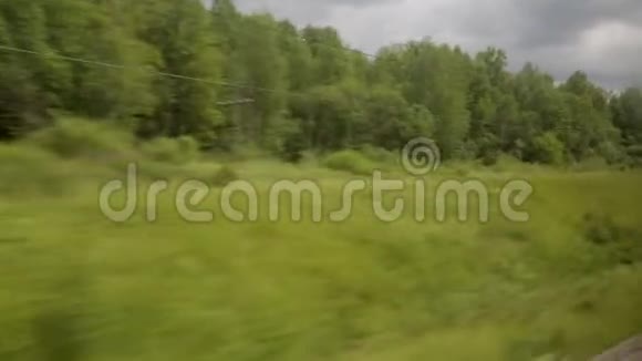 从火车车窗望去的景色铁轨风景树木夏日阳光明媚视频的预览图