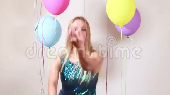 金发女人在摄影棚里用闪亮的手绳跳舞的慢动作视频的预览图