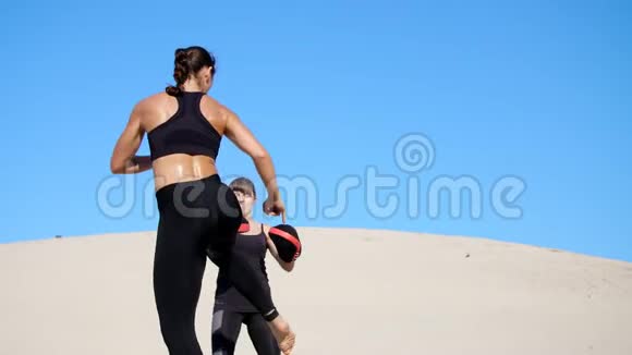 两个穿着黑色健身服的年轻女子在荒无人烟的情况下穿着一双运动服锻炼踢腿训练打架视频的预览图