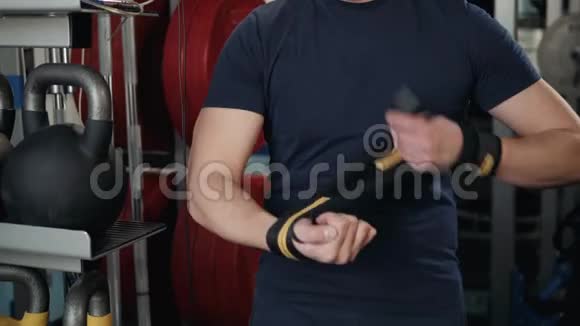一个强壮的拳击手的特写他穿上红色的带子准备战斗准备锻炼训练视频的预览图
