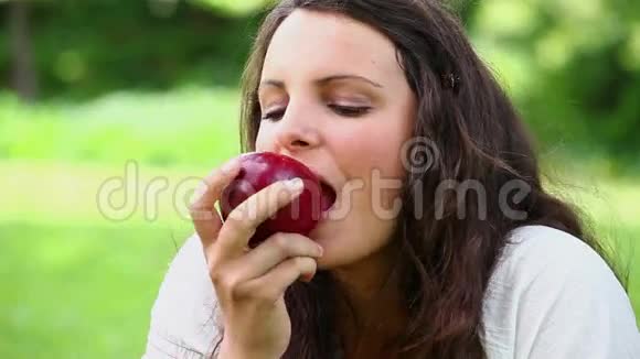 快乐的女人吃红苹果视频的预览图