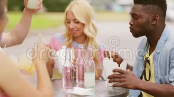 在户外餐桌上享用食物和饮料的朋友视频的预览图