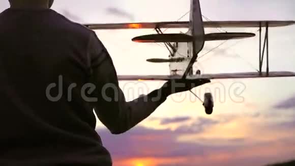 自制的飞机在儿童手中的惊人日落背景4k视频的预览图