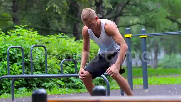 运动员在夏季树下的城市公园运动前热身以进行运动健身腿腿视频的预览图