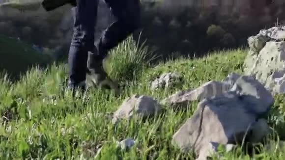 登山者穿着登山靴踏着山景的石头视频的预览图