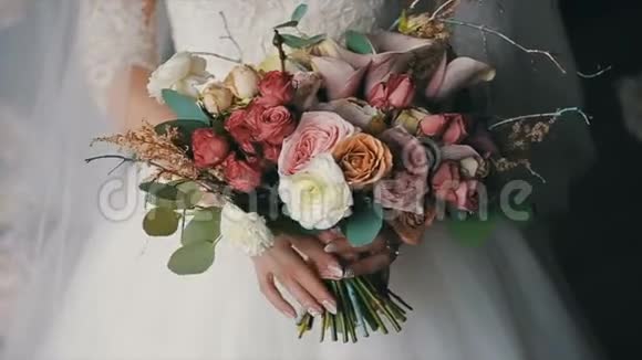 新娘捧着美丽的婚礼花束婚礼当天的新娘花束美丽的花束视频的预览图