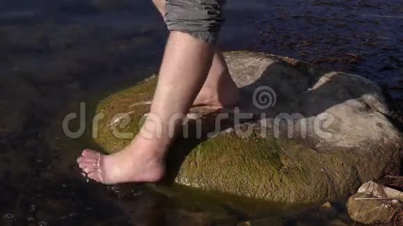 光脚踏石傍水的人视频的预览图