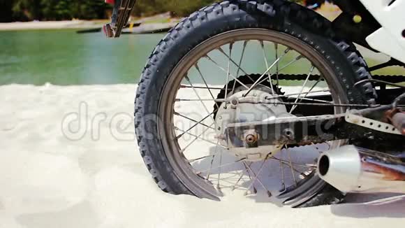 摩托车越野车车轮开始旋转踢起地面和沙子视频的预览图