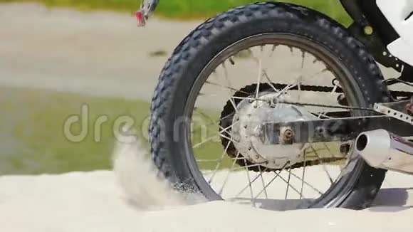 摩托车越野车车轮开始旋转踢起地面和沙子视频的预览图