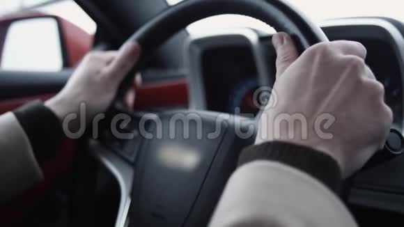 大亮的一天驾驶昂贵汽车的男性手臂在方向盘上视频的预览图