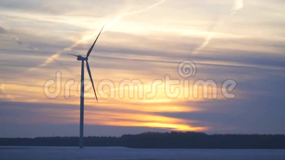 时间流逝冬季田野中间的一个单独的风力发电机视频的预览图