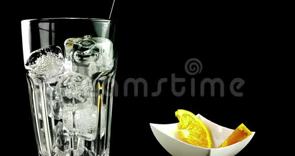 慢镜头拍摄喝一杯带有冰块的斯普里茨开胃酒橙鸡尾酒气泡运动视频的预览图