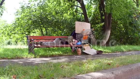 城市公园长凳上无家可归的老人的景色视频的预览图