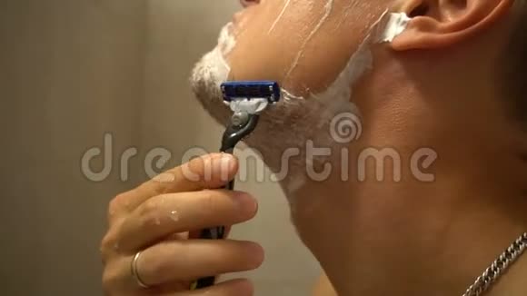 带泡沫和手动刮胡子的成年男子视频的预览图