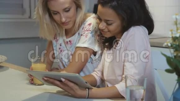 两个漂亮女孩在家里用平板电脑的肖像视频的预览图