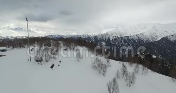 无人驾驶飞机飞越滑雪缆车观看4K森林覆盖的雪山视频的预览图