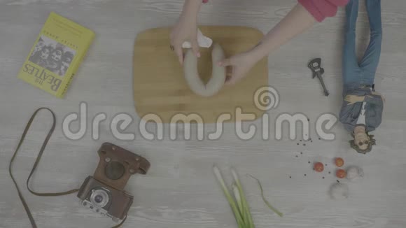 手把香肠放在木板上桌子上摆着一本书一台旧相机洋葱大蒜和玩具的镜头风格视频的预览图