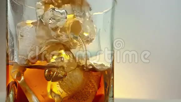 在杯中加入冰块在温暖的白色背景下加入酒保倒入威士忌放松时间与威士忌视频的预览图