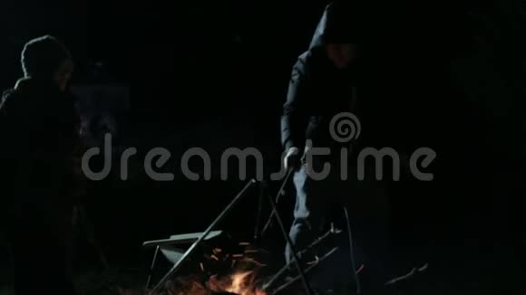 夜晚篝火旁父子的剪影视频的预览图